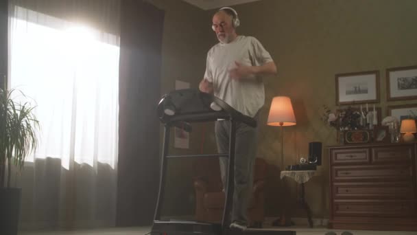 Дедушка тренируется на беговой дорожке — стоковое видео