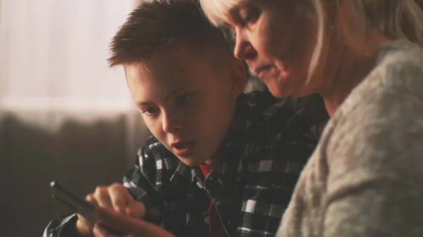 Teenager pomocí babičky používat mobilní telefon — Stock fotografie