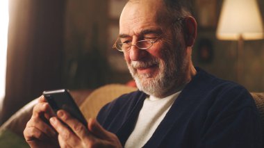 Akıllı telefonlu son sınıf öğrencisi gülüyor.