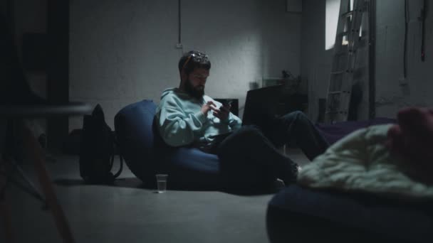 Man using smartphone in a bomb shelter — Vídeos de Stock