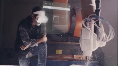 VR kulaklıklı bir işçi, geliştirilmiş gerçeklik teknolojisini kullanarak, 3D modeli ve görevi robotik bir kol ile tamamlama sürecini uzaktan kontrol etmek ve görselleştirmek için değirmencilik sürecini izler..