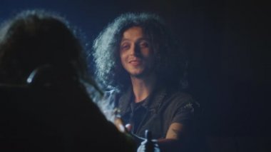 Tiyatro oyuncusu dizlerinin üzerinde duruyor ve bir prova sırasında loş bir sahnede engelli bir aktrise romantik bir şarkı söylüyor.