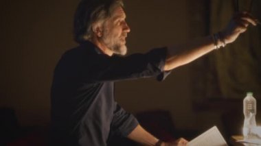 Tiyatro yönetmeni, oyunculukla ilgili tavsiyelerde bulunuyor ve performans provası sırasında senaryoyu okuyor.