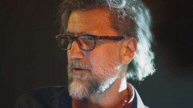 Director in glasses communicating with the actors and giving them recommendations about acting on the stage of the theater