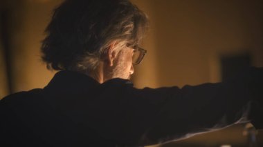 Yönetmen loş bir tiyatroda tiyatro provası sırasında oyuncularla konuşur ve konuşur.