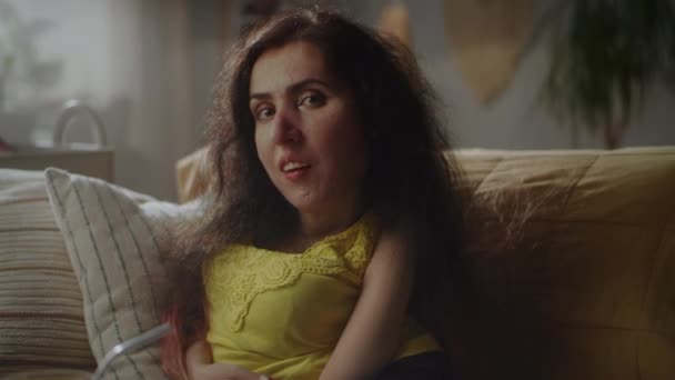 Beautiful Woman Spinal Muscular Atrophy Sitting Sofa Home Smiling Camera — Stockvideo
