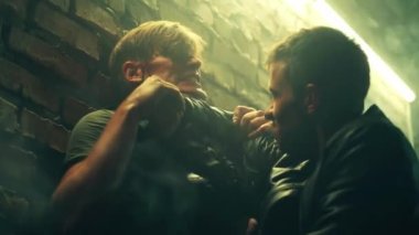 Gangster ya da katil polis memurunu karanlık bodrumdaki tuğla duvarın yanında LED lambalarla boğup olay yerinden ayrıldıktan sonra öldürmüş. Eylem ya da suç filmi sahnesi