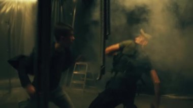 Televizyon ekranları için film sahnesi montajı. İki karakter karanlık bir odada kavga ediyor ve bir terörist, patlayıcılı bir adamı mayınlayan silahlı bir intihar bombacısı. Aksiyon filmi sahne dövüşü sahnesi 3..
