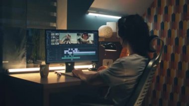 Kulaklıklı adam geceleri ofisten bilgisayar başında çalışıyor ve profesyonel programdaki müşteriler için astronotlarla video düzenliyor.