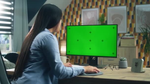 アジアの女性はテーブルに座って 余暇にインターネットをサーフィンしたり 自宅からリモートで作業しながら パーソナルコンピュータの画面を見ています フリーランス 緑の画面とクロマキー — ストック動画