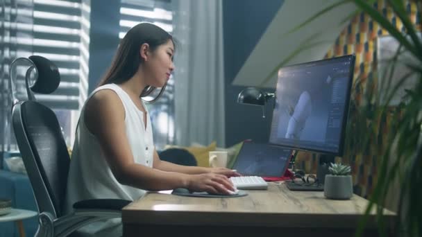 アジアの女性3Dデザイナーは 自宅のデスクに座って遠くの仕事をしながら コンピュータやタブレットを使用してビデオゲームのキャラクターを作成し 描画します 3Dモデリング — ストック動画