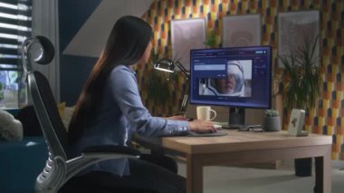 Asyalı kadın evdeki masada oturuyor ve uzaktan çalışma sırasında profesyonel photoshop programında kadın astronotların fotoğraflarını düzenliyor.