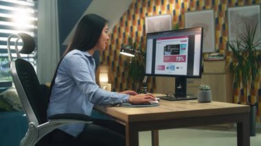 Kadın Asyalı web tasarımcısı evde uzaktan proje üzerinde çalışırken profesyonel inşaatçılarda web sitesi oluşturmak için kişisel bilgisayar kullanıyor. Bağımsız