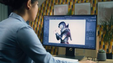 Kadın 3D tasarımcı bilgisayar kullanarak bilgisayar kullanarak oyun için karakter yaratıp çizerken aynı zamanda uzak mesafelere çalışıyor. 3B modelleme
