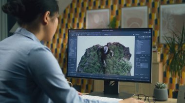 Asyalı kadın 3D tasarımcı video oyunu karakteri için animasyon yapıyor. Modern bilgisayar ve 3D modelleme projeleri için yazılım kullanıyor.