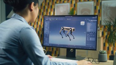 Üç boyutlu modelleme programında çalışan Asyalı kadın ev ofisinden uzaktan kumandalı ve modern robotun 3 boyutlu prototipini yapıyor.