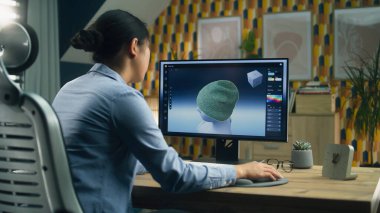 Kadın tasarımcı evden uzaktan çalışırken bilgisayar ve profesyonel yazılım kullanarak kıyafetlerin 3 boyutlu görselleştirmesini yapıyor