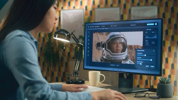 亚洲女性自由撰稿人在总部远程工作时 与宇航员一起在照相馆的计算机上编辑照片 — 图库照片
