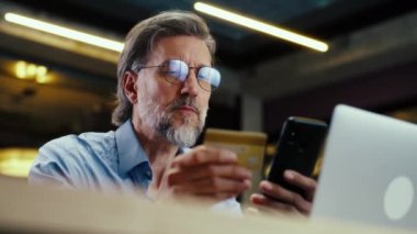 Telefon kullanan iş adamı, banka kartından para transfer eden, modern pazarlama şirketinin ofisinde çalışırken internet üzerinden hizmet ödeyen. E-ticaret ticaret merkezi