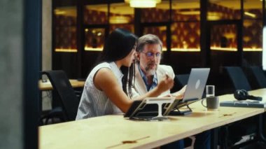 Modern ofiste bilgisayar ve dijital tablet bilgisayar kullanarak iş kurma projesini tartışan çok ırklı girişimciler. E-ticaret şirketi. İş stratejisi üzerine takım çalışması