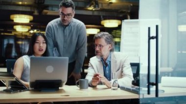 Modern ofiste dizüstü bilgisayar kullanarak iş stratejisi ya da başlangıç projesini tartışan çok ırklı yaratıcı işçiler. E-ticaret şirketi. Başlangıç projesi üzerinde çalış