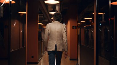 Modern koridorda takım elbiseli başarılı bir iş adamının arka planı. Erkek ofis çalışanı işe gidiyor. E-ticaret pazarlama şirketinin ofis koridoru