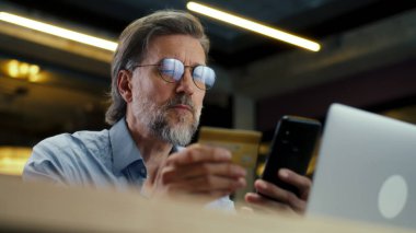 Telefon kullanan iş adamı, banka kartından para transfer eden, modern pazarlama şirketinin ofisinde çalışırken internet üzerinden hizmet ödeyen. E-ticaret ticaret merkezi