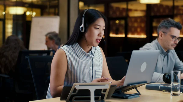 Asiatin Headset Gespräch Mit Kunden Mit Laptop Und Digitalem Tablet — Stockfoto