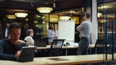 Asyalı bir kadın, modern ofisteki meslektaşlarına proje tasarısı, mühendislik başlangıç projesi ve büyüme stratejisi sunuyor. İş arkadaşları başarılı sunumlarını alkışlıyorlar. İş toplantısı.