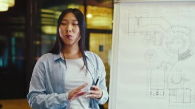 İş eğitimine liderlik eden Asyalı iş kadını. Ofis konferans odasında iş toplantısı. Modern ofisteki iş arkadaşlarına projenin taslağını ya da mühendislik projesini sunan kadın mühendis.