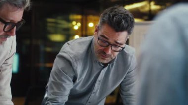 CEO konuşuyor, ofis konferans odasında önde gelen iş toplantısı. Çeşitli ofis çalışanları şirket stratejisini tartışıyor, başlangıç projesi üzerinde çalışıyorlar. Takım çalışması ve beyin fırtınası.