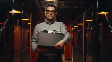 Ofis koridorunda elinde kitaplarla ve kişisel eşyalarla yürüyen takım elbiseli üzgün bir adam kovuldu. Meslektaşlarına veda etti, kameraya baktı. Erkek çalışan pazarlama şirketinden ayrılıyor.