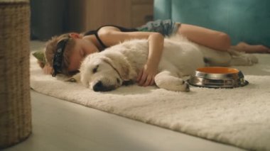 Kucaklayan köpek, gündüz vakti halıda uyuyan, rüya izleyen, boş zamanlarını evde birlikte geçiren, rahatlayan ve güç toplayan bir kız. Golden retriever.