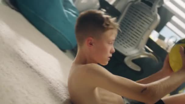 Konzentrierter Kleiner Junge Mit Geprelltem Arm Liegt Auf Dem Teppich — Stockvideo