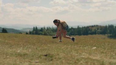 Genç fotoğrafçı dijital kamera kullanarak güzel bir film çekiyor. Kız hareketli içerik yaratır, sonuçları sallar ve mutlu hisseder, boş zamanlarını dışarıda geçirir.