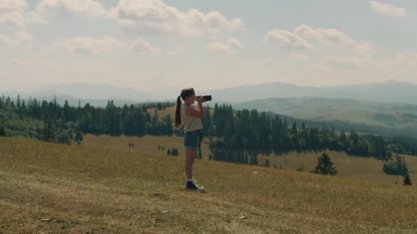美しい緑の丘の中腹に若い写真家の撮影風景 自然の写真を撮る 女の子は素晴らしい写真でポートフォリオを埋め レジャー時間を過ごす屋外 — ストック動画