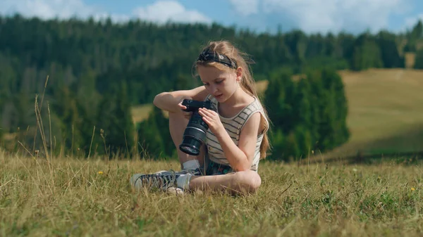 Młody Fotograf Ogląda Wyniki Pracy Siedzi Łagodnym Trawiastym Wzgórzu Dziewczyna — Zdjęcie stockowe