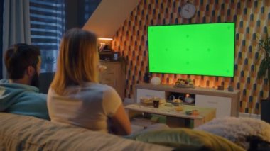 Kanepede oturan çift, son dakika haberleri, film ya da TV 'de patates kızartması ve pizzayla dizi izliyor. Karı koca geceleri evde dinleniyor ve dinleniyorlar. Yeşil ekran. Kromakey. Ev sineması.