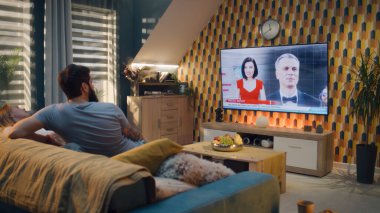 Oturma odasındaki kanepede çay içen mutlu çift, film festivali haberleri izliyor, yönetmenler ve aktörler ödüllendiriliyor. Erkek ve kadın evde birlikte vakit geçiriyorlar. TV canlı yayın.