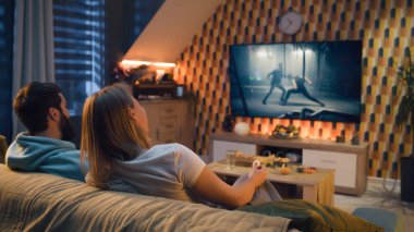 Mutlu çift kanepede oturuyor, TV 'de aksiyon filmi izliyor ya da canlı yayında kriminal blockbuster izliyor, konuşuyor ve oyunculuğu tartışıyor, abur cubur yiyor, pizza yiyor, cips yiyor. Akşamları evde dinlenen eşler.