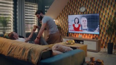Oturma odasındaki kanepede çay içen mutlu çift, film festivali haberleri izliyor, yönetmenler ve aktörler ödüllendiriliyor. Erkek ve kadın evde birlikte vakit geçiriyorlar. TV canlı yayın.