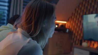 İlginç aksiyon filmi izleyen odaklanmış bir çift ya da TV 'de modern iç mekânlı bir oturma odasında abur cubur yiyen bir suçlu. Erkek ve kadın hafta sonları evde dinleniyorlar..