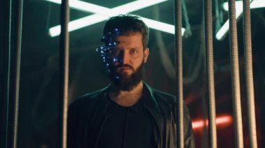 LED ışıkları olan bir kulaklık takan genç adam siyah asma çubukların arkasında durup kameraya bakıyor. Siberpunk ve fütüristik kavram. Arka planda neon ışıkları.