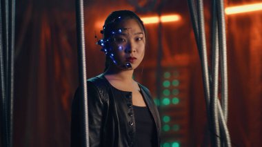Siyah deri ceketli siber punk kız siyah askılı çubukların arkasında sıkıştı. Yoğun yüz ifadeleri. Fütürist gözlüklü ve kulaklıklı Asyalı kız. Cyborg, bilim kurgu, neon ışıklar..