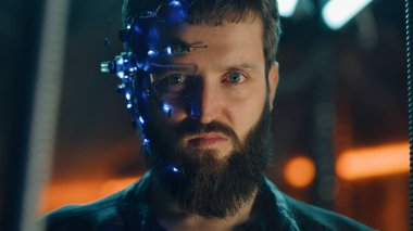 Siyah deri ceketli sakallı genç adam kameraya şiddetle bakıyor. Tek gözlü gözlüklü ve kulaklıklı adam kaçmasın diye siyah çubukların arkasında asılı kalmış..