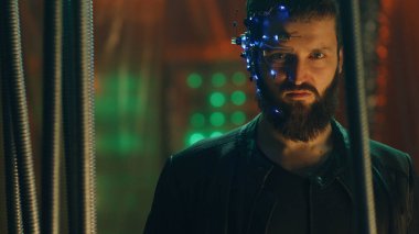 LED ışıkları olan bir kulaklık takan genç adam siyah asma çubukların arkasında durup kameraya bakıyor. Siberpunk ve fütüristik kavram. Arka planda neon ışıkları.