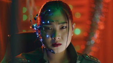 Siberpunk bir kız bilgisayar ekranına bakıyor. Tek gözlü ve mikrofonlu fütürist gözlükler takıyor. Kameraya bakmak için bilgisayara bakmayı keser. Siber ve bilim kurgu geçmişleri.