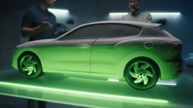 Deneyimli otomotiv mühendisleri prototip araba modelini ışığın farklı tonlarında inceleyerek gelecekteki arabanın rengini seçiyorlar. Dijital tablet ve aydınlatma tablosunda özel uygulama kullanılıyor.