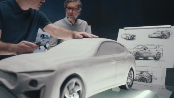 Kıdemli Otomotiv Mühendisleri Tasarımın Kalem Çizimlerine Bakan Arabanın Prototip Modeli — Stok video