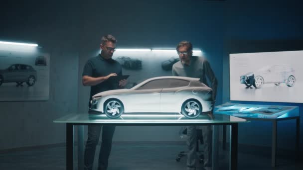 Έμπειροι Μηχανικοί Αυτοκινήτων Συζητούν Σχεδιασμό Μπροστά Από Ένα Πρωτότυπο Μοντέλο — Αρχείο Βίντεο